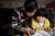 CFS volunteer Xiaomei (left) helps Anxiang with her homework.