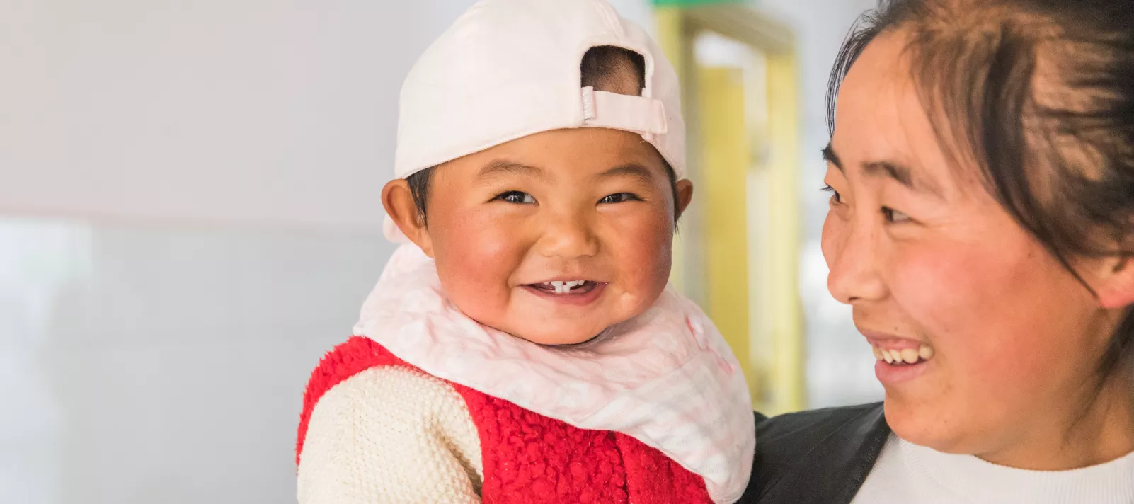 2018年，在云南省玉龙妇幼保健院，一名妈妈带孩子做完检查后步出诊室。
