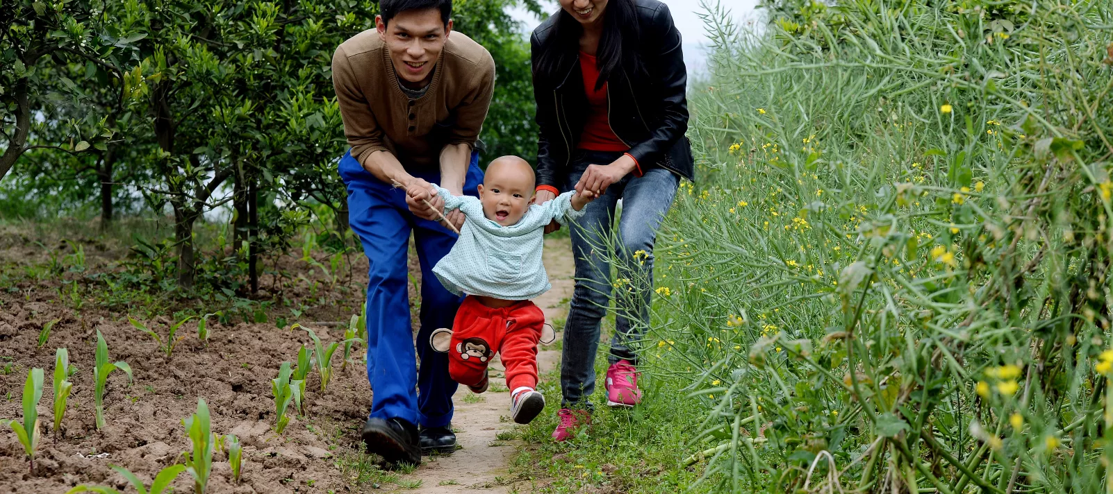 A child plays with his parents in Aijia Village, Yichang City, Hubei Province, in April 2015. 