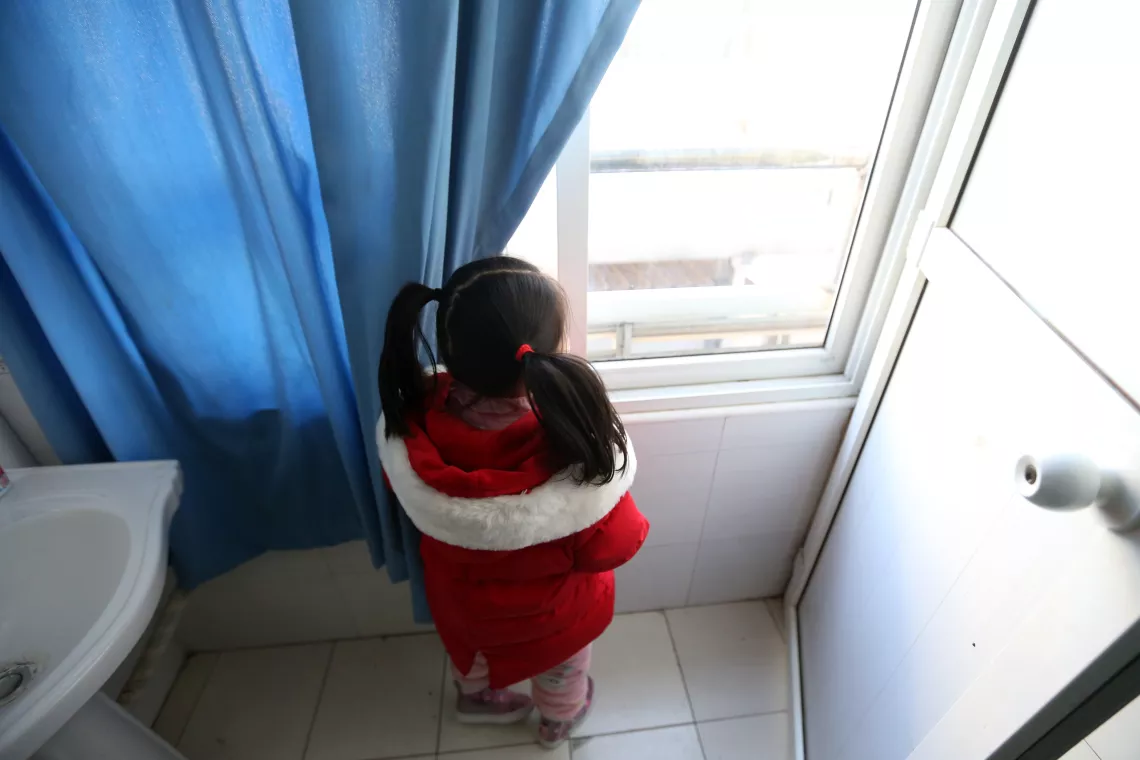 Yuanyuan looks out the window of her room in a hospital affiliated to the Wuhan University of Science and Technology on 17 February 2020. 