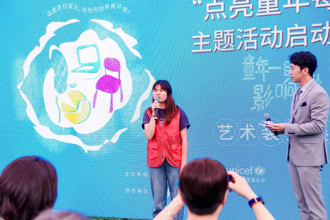 2023年5月31日，在北京市中国儿童中心举办的“点亮童年每一刻”主题活动启动仪式上，来自广西壮族自治区隆安县的儿童主任卢丹丹（左）分享自己参与亲职教育活动的经历。“点亮童年每一刻”主题活动由中国儿童中心和联合国儿童基金会驻华办事处联合主办，中国儿童福利和收养中心协办，致力于为家长提供实用且有效的养育方法，通过“尊重、理解、沟通、信任和示范”，与孩子建立积极融洽的关系。