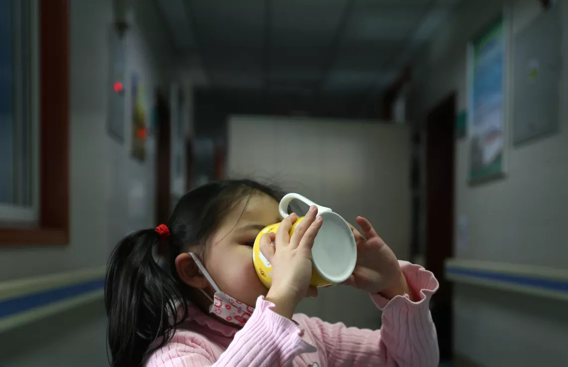 Yuanyuan drinks water with a cup.