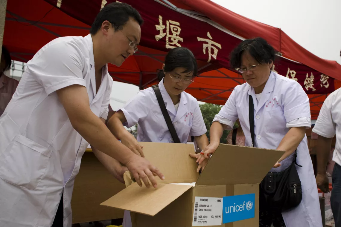 2008年5月31日，在都江堰的帐篷医院内，医护人员正在打开联合国儿童基金会提供的医疗物资。