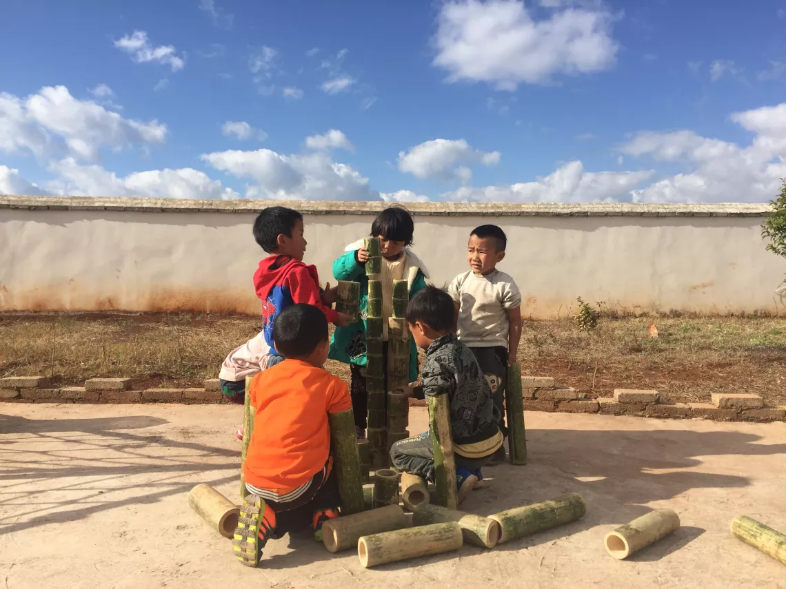 Children build a 'castle' with bamboo pipes at Eyi Kindergarten in Yunnan Province.