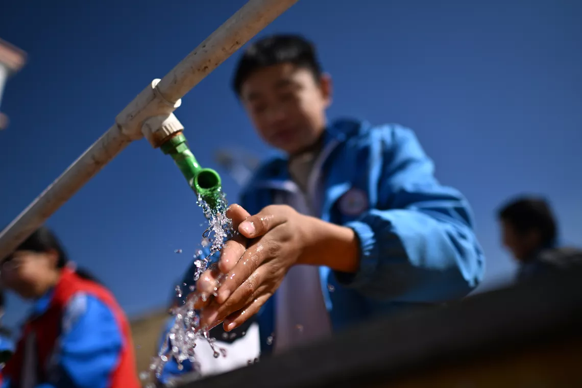在青海省海东市互助土族自治县台子乡中心学校，一名学生在使用厕所后洗手，台子乡中心学校是环境卫生特别项目学校之一（11月1日摄）。