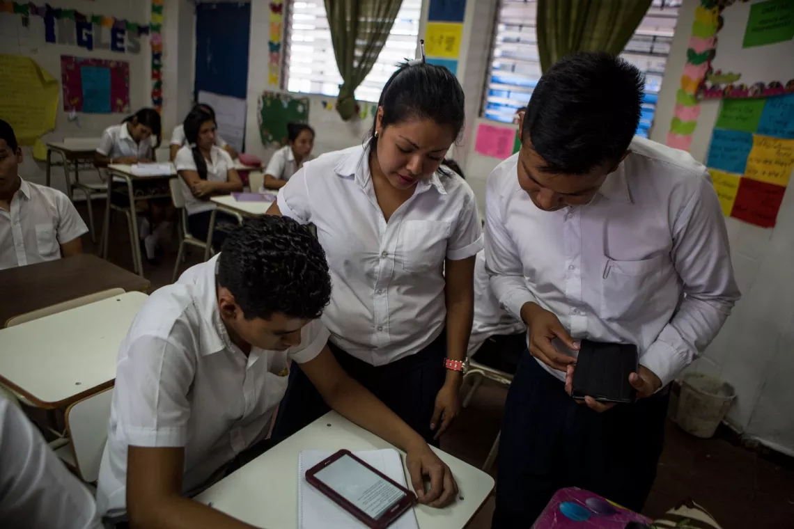 在萨尔瓦多，由联合国儿童基金会支持的“引领和传播工作网络项目”中，圣特克拉市一所学校的一名老师及其学生们正在使用平板电脑，为即将开展的一项关于互联网使用和安全的调查做准备。