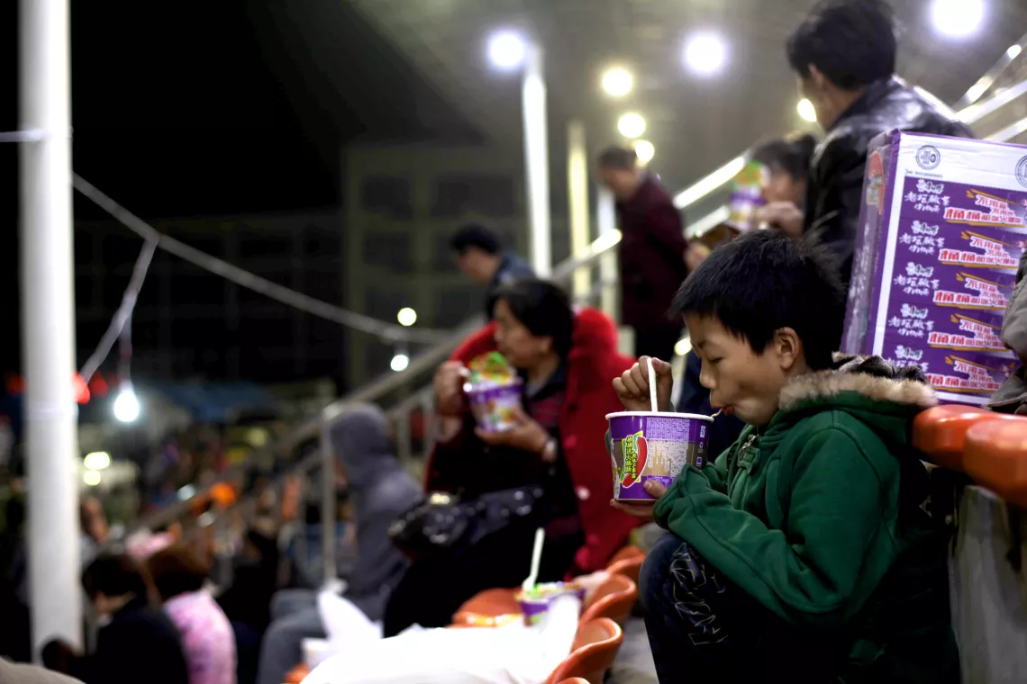 April 21, 2013, a child eating instant noodle in a temporary settlement area in Baoxing County.