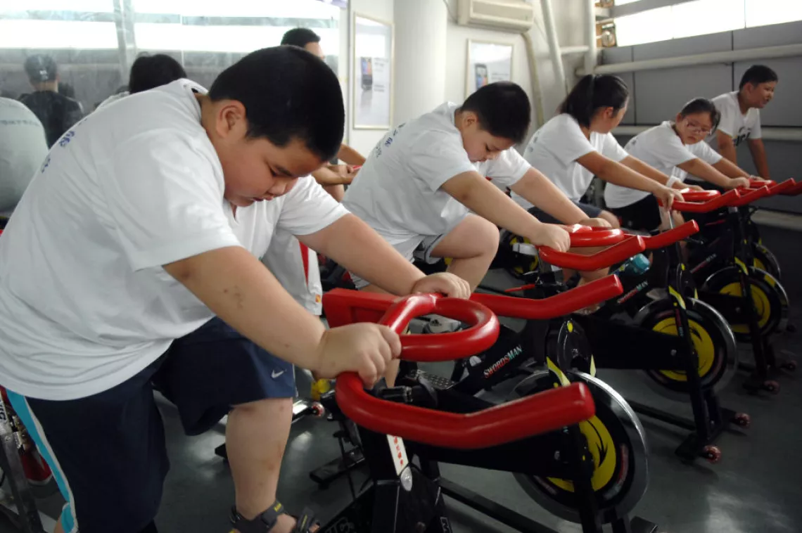 2011年7月21日，孩子们在杭州黄龙体育馆参加减肥夏令营里的疯狂单车健身项目。