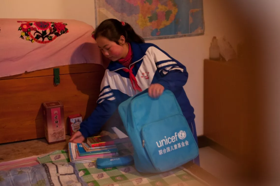 Yang Mei, 13, packs her shoulder bag before going to school.