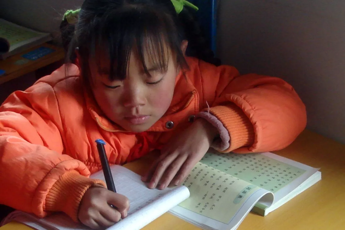 A girl studies in a prefabricated classroom.