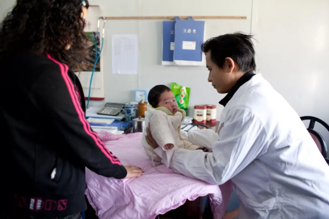 一个医生在四川省青川县妇幼保健院给45天大的高靖婷做检查。
