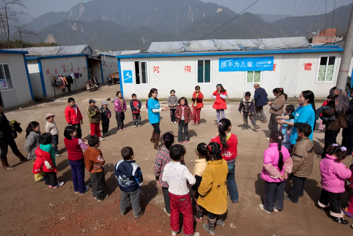 Children in a resettlement camp play a group game at a UNICEF-supported Child Friendly Space shortly after the Wenchuan earthquake in 2008.