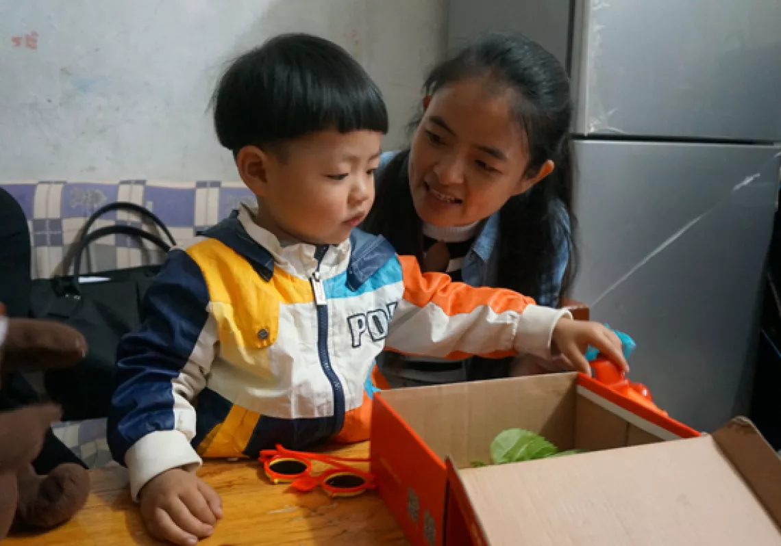 Xiao Zeng and her 3-year-old son play at home.