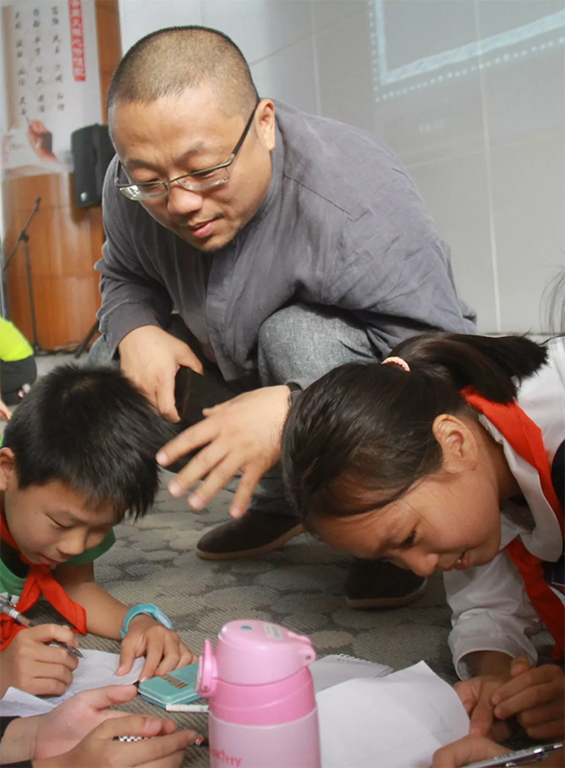 Zhang Haibo, Deputy Director of the Guangzhou Children's Palace discussing the design of a questionnaire with child researchers.