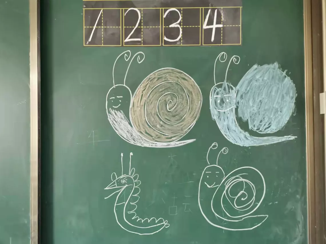 黑板上有四只用粉笔画的形象不同的蜗牛。