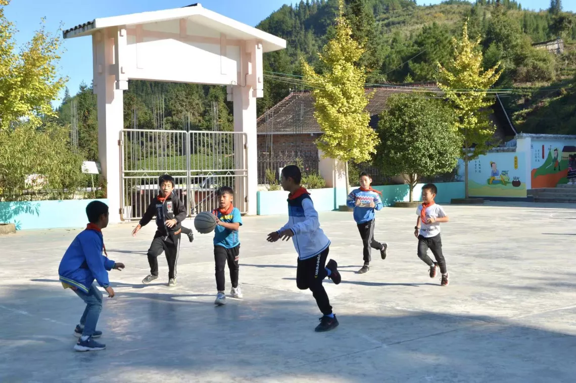 广西三江侗族自治县八江镇岩脚小学学生在打篮球。