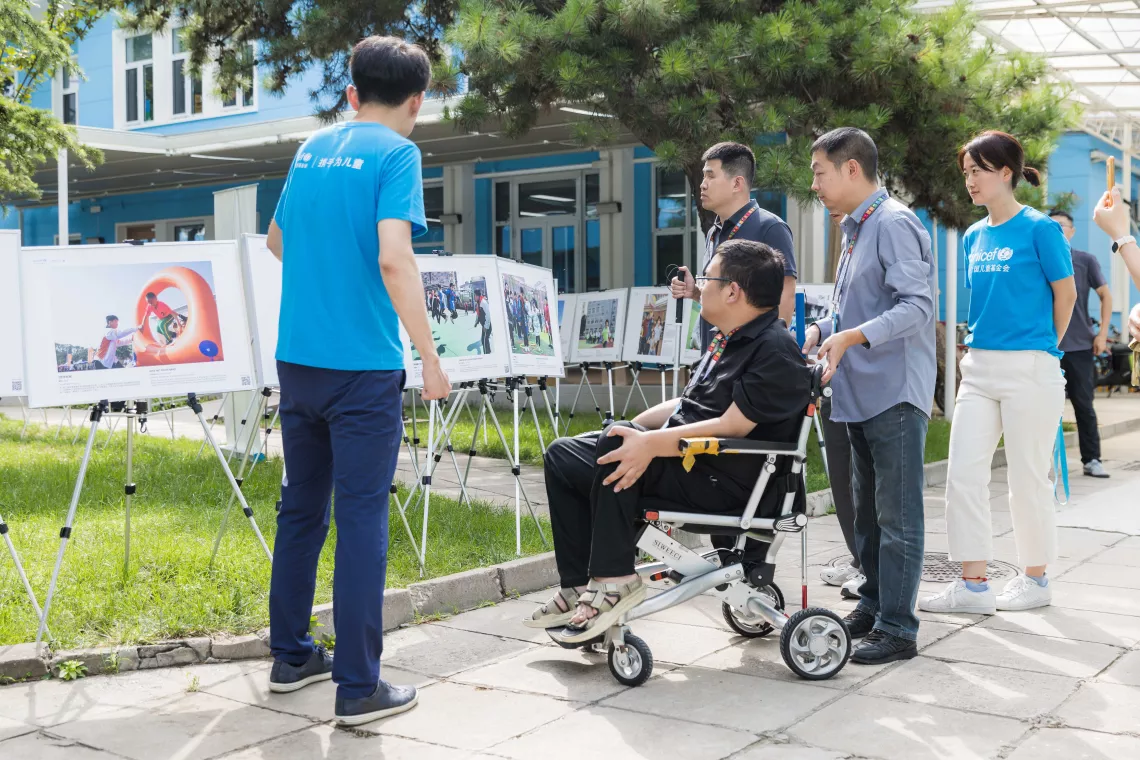 UNICEF staff give participants a guided tour of UNICEF's ‘Inclusion for a Shared Future’ disability inclusion photo exhibition.