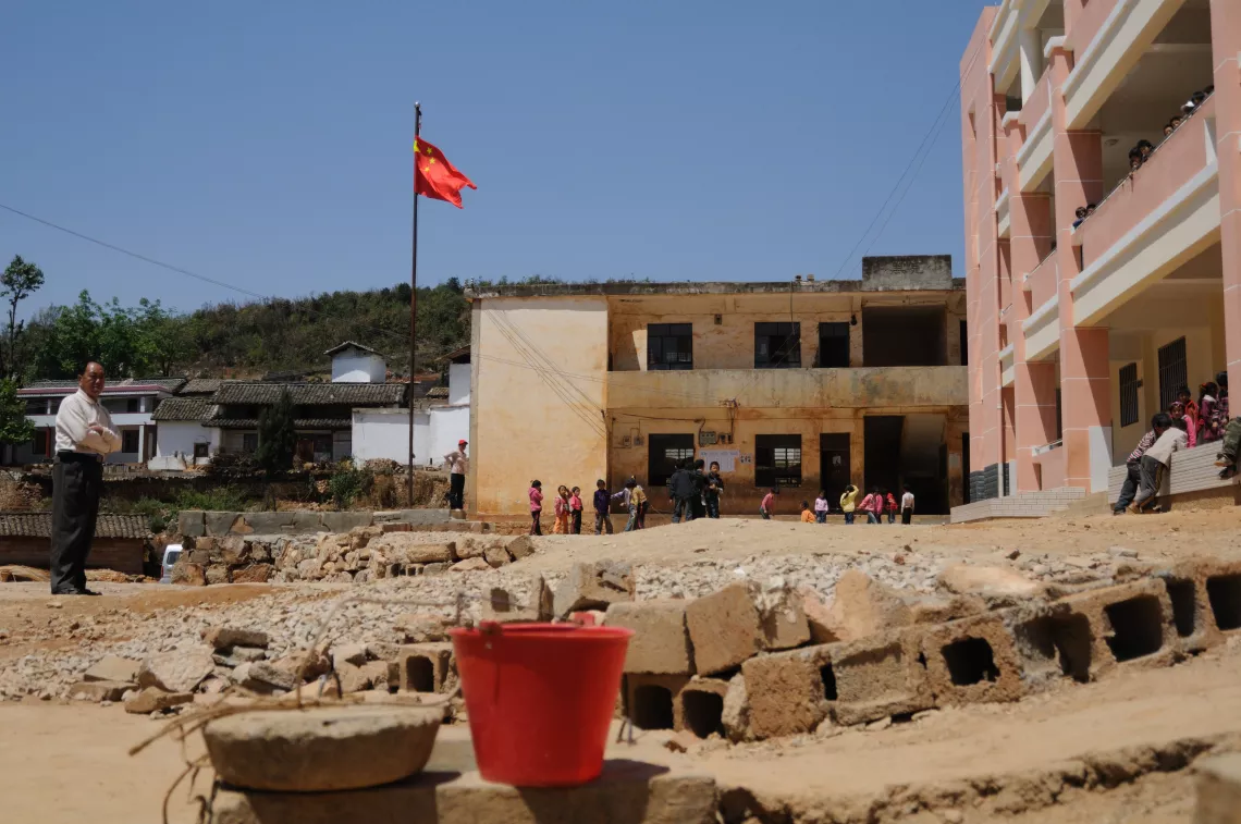 A water cellar (foreground, with a red bucket) keeps the water transported by trucks in Shanhei Complete Primary School.
