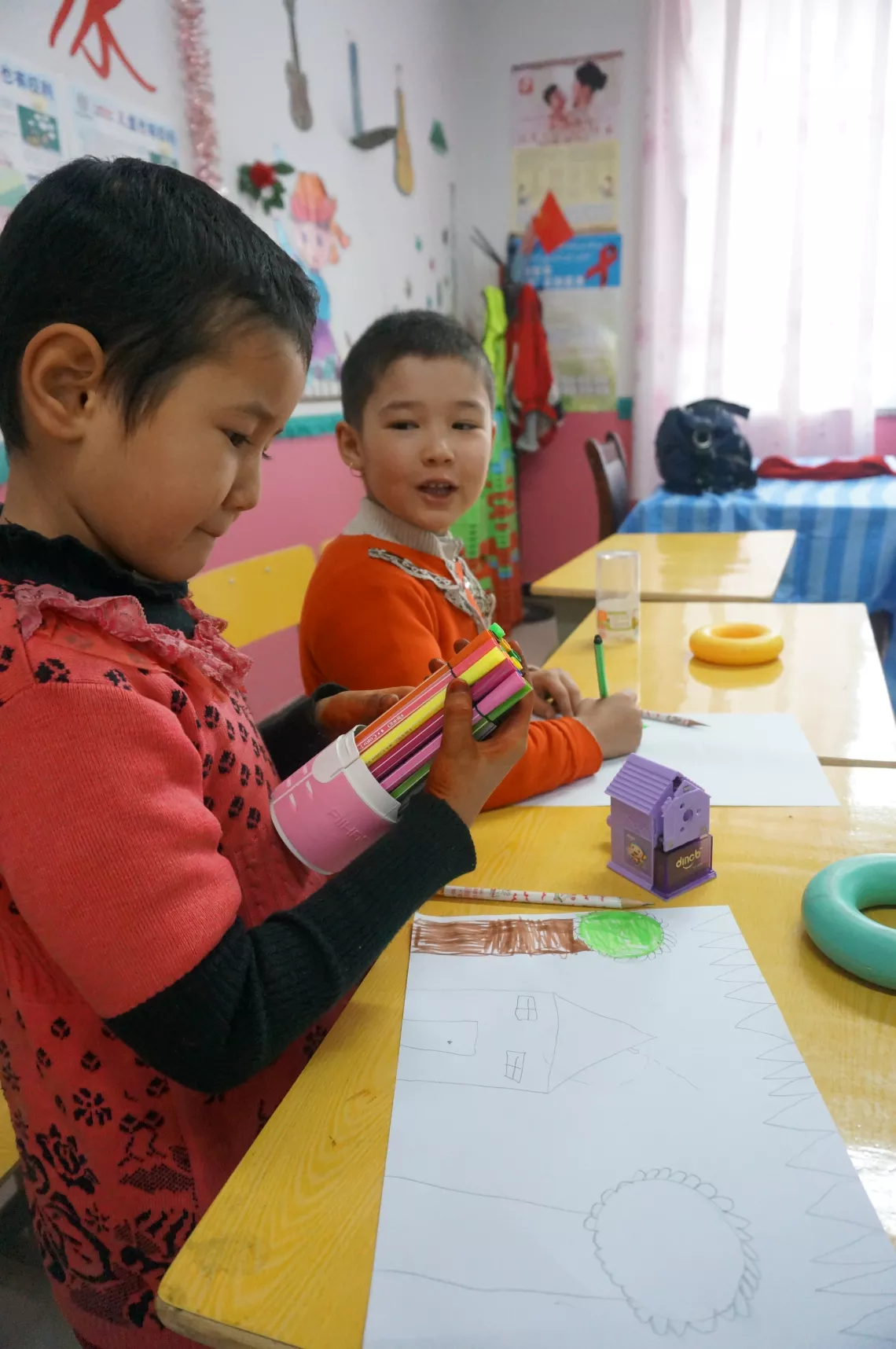 Two girls paint pictures in the children's space in Yining County, Xinjiang Uyghur Autonomous Region.