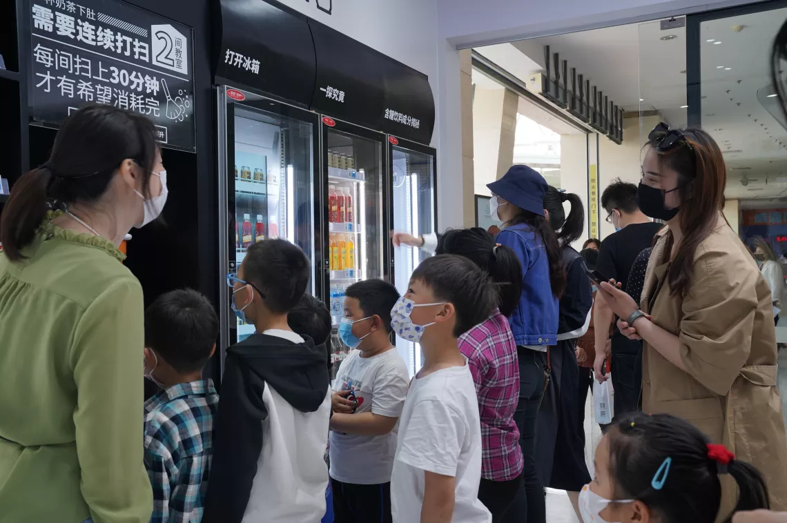 Parents bring their children to visit UNICEF’s ‘Know Your Food’ Convenience Store at the Weihai Science and Technology Museum in Shandong Province on 21 May 2022.