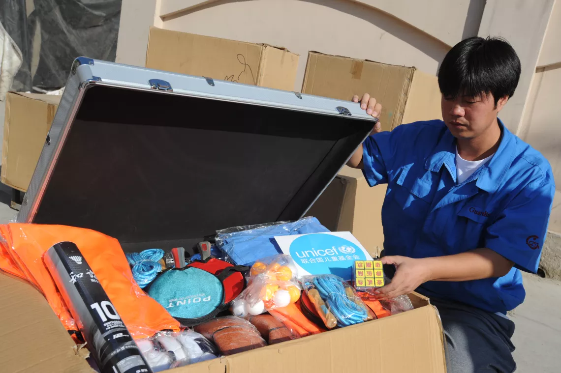 A worker is packing children’s sports and recreation kits to be used in Child Friendly Spaces to be established in Yiliang County.