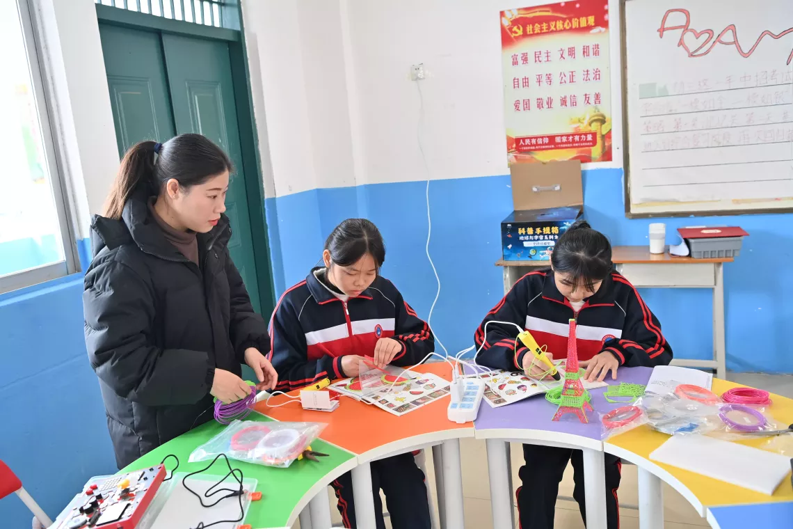 Students Xu Ziyu (C) and Nong Caihang (R) make 3D models following their teacher's guidance in Shimin Experimental School in Tiandeng County, south China's Guangxi Zhuang Autonomous Region, Dec. 27, 2023.
