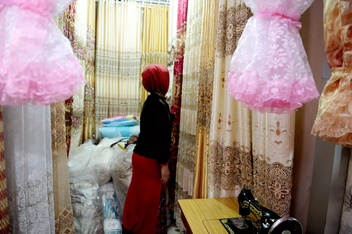 一位住在伊犁的艾滋病感染者通过预防母婴传播项目获得了小额贷款和技术培训，开了一家窗帘店。