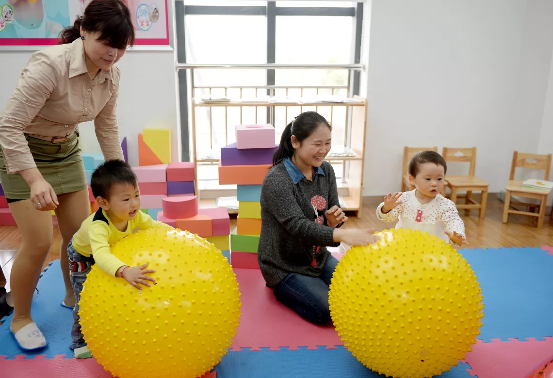 Jia Yadi (kneeling), a young mother from Tanxihu community in Xiangyang city in Hubei Province, described her 18-month-old daughter, Qiqi, as lively and outgoing. But she worried about Qiqi’s unwillingness to share toys.