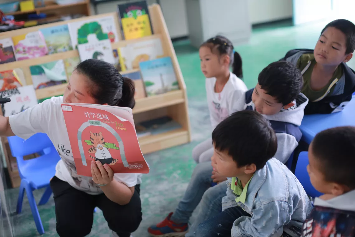 Liu Fen tells a story to kids at the Yelang Village Kindergarten.