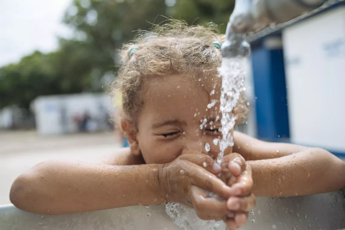 A girl drinks water from a UNICEF-supported tap in Colombia, where thousands of Venezuelans pass by on their way to start their migration journey