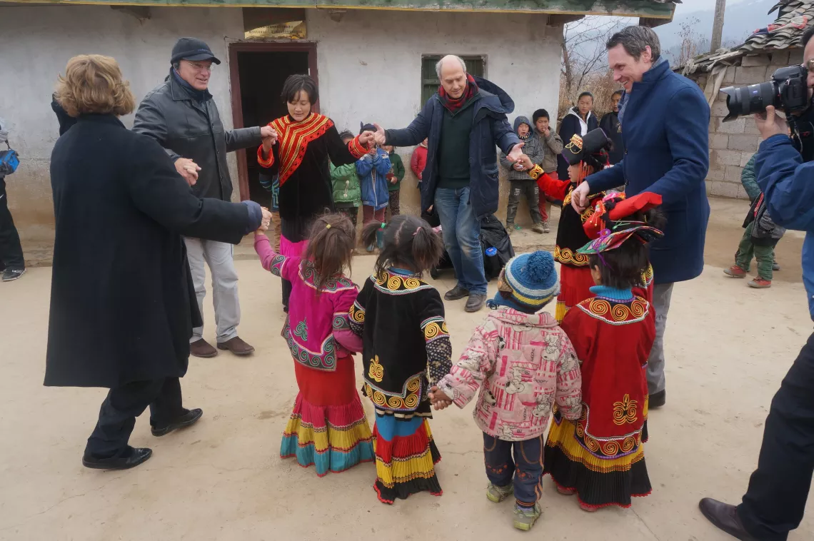 Daniel Toole, UNICEF Regional Director for East Asia and the Pacific, Gillian Mellsop, UNICEF`s Representative to China, Roberto Benes, UNICEF's Representative to Mongolia, and Robert Scherpbier, UNICEF China`s Chief of Health, Nutrition and WES Section, join a children's dance at Muzhaluo Village in Zhaojue, Liangshan, Sichuan Province, China on January 15, 2015.