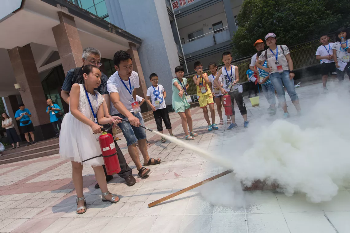 With the help of teachers, Wang Yitong puts out a fire.