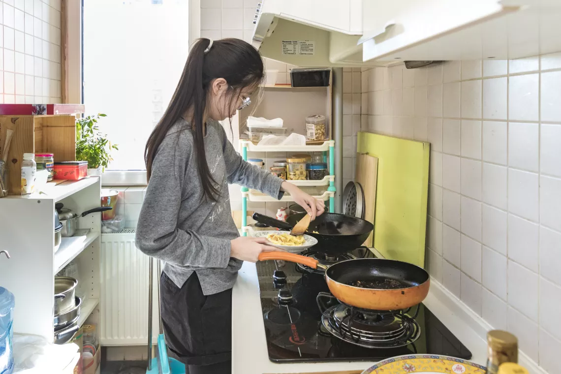 Xiaoyu helps her family cook lunch.