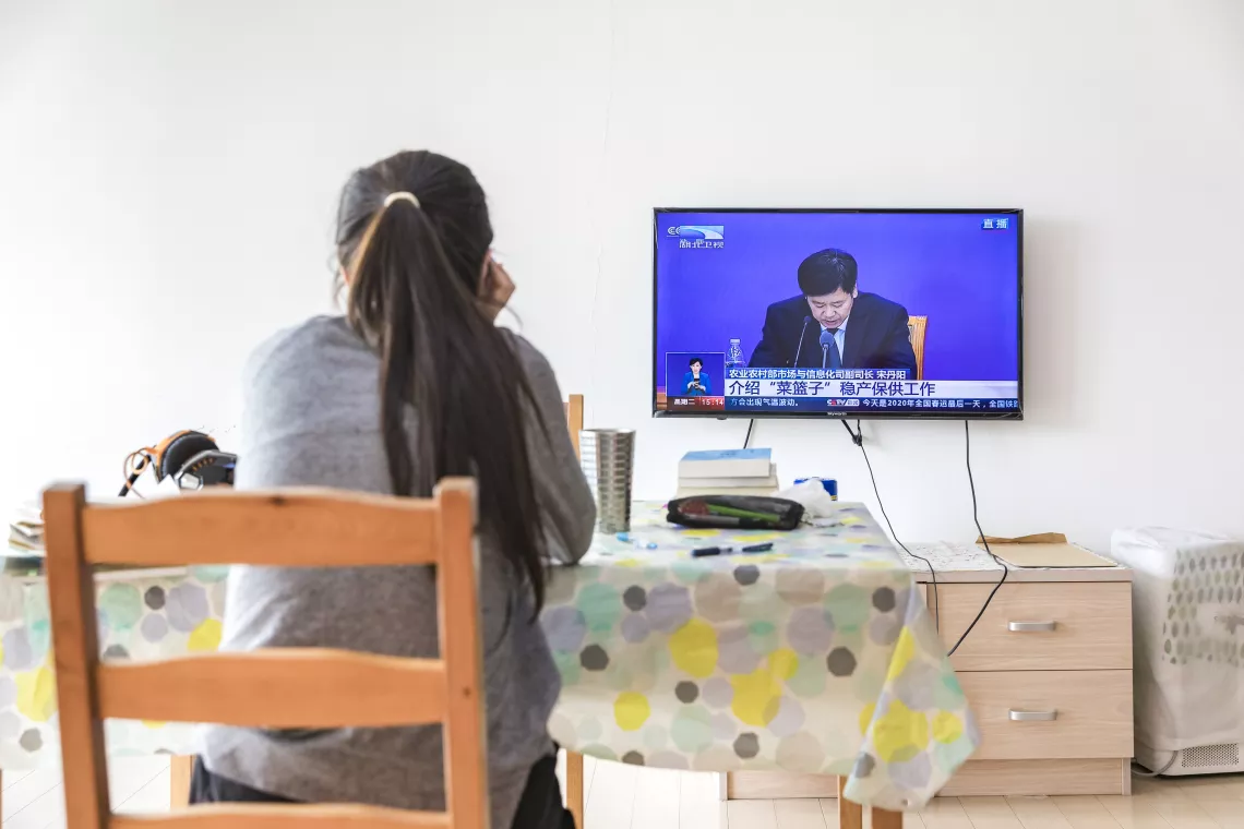Xiaoyu watches  TV. The Government of China is giving a press briefing on the COVID-19 outbreak.