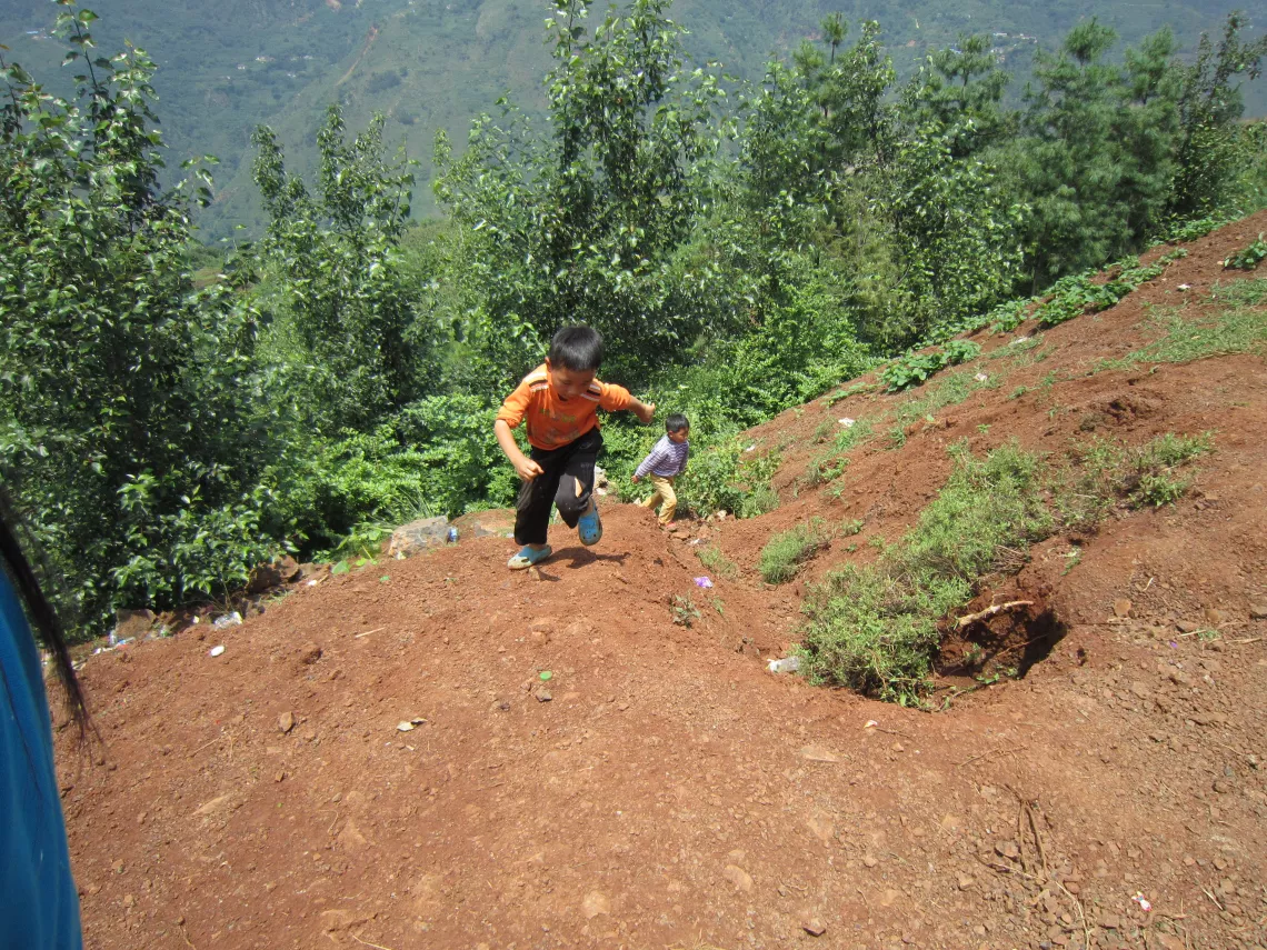 While the caregivers are busy setting up tents and rebuilding their lives, some children are playing on the hillside, which is very dangerous.