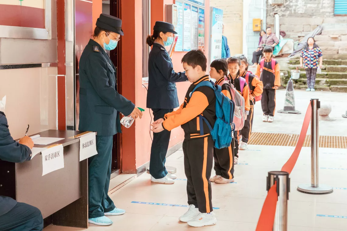 2020年6月3日，重庆忠县任家镇义兴学校的学生在进入校园前接受体温检测并使用免洗洗手液洗手。