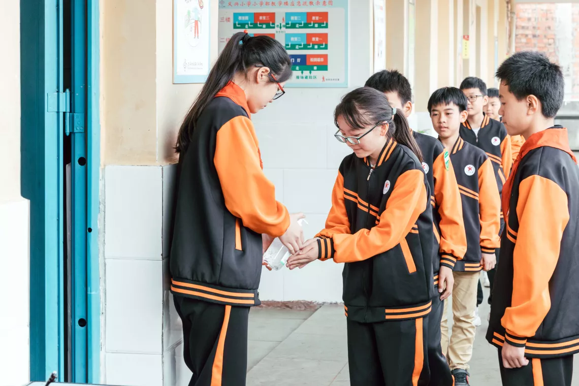 2020年6月3日，重庆忠县任家镇义兴学校的学生在进入校园前使用免洗洗手液洗手。