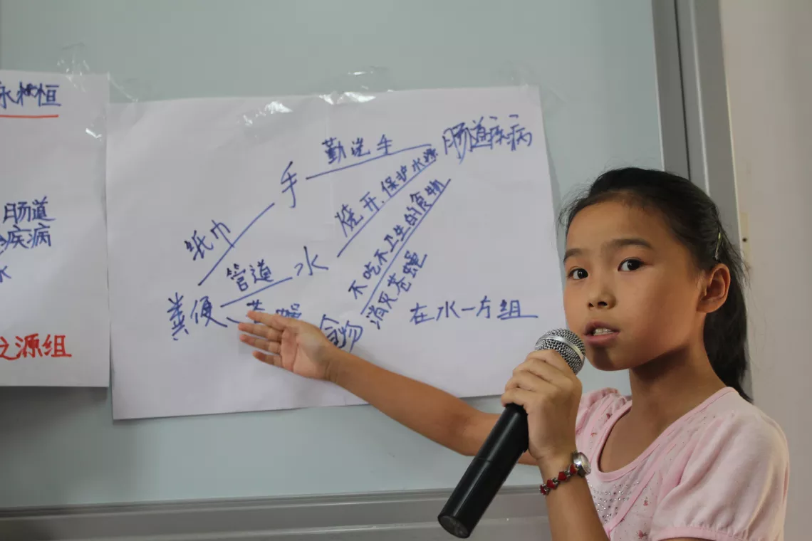 Children in Ganjing primary school in Zhong County are showing their discussion results about transmission route of sanitation-borne disease.
