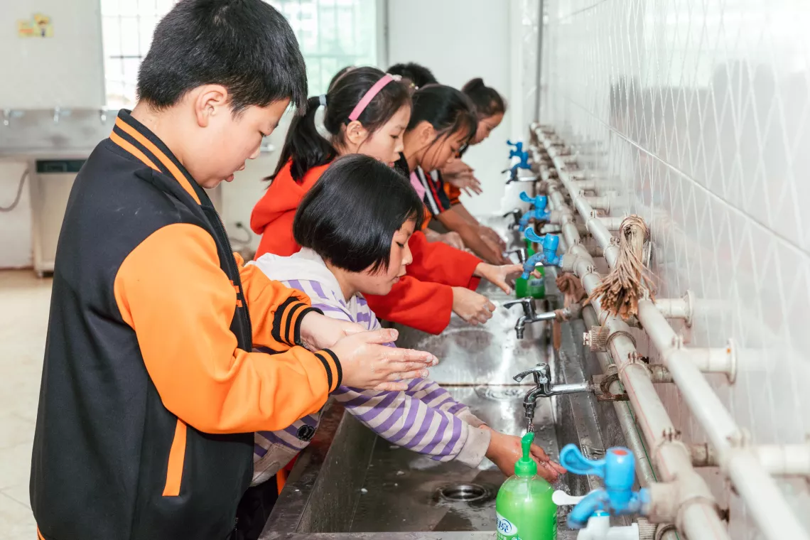 Students wash hands with liquid soap before lunch at Yixing School of Zhong County in Chongqing, China on 3 June 2020.