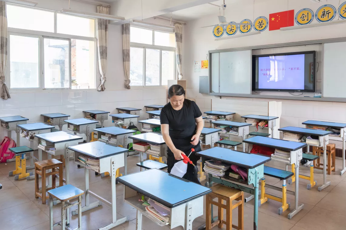 2020年6月3日，重庆忠县任家镇义兴学校内，一名教师在为教室课桌椅消毒。
