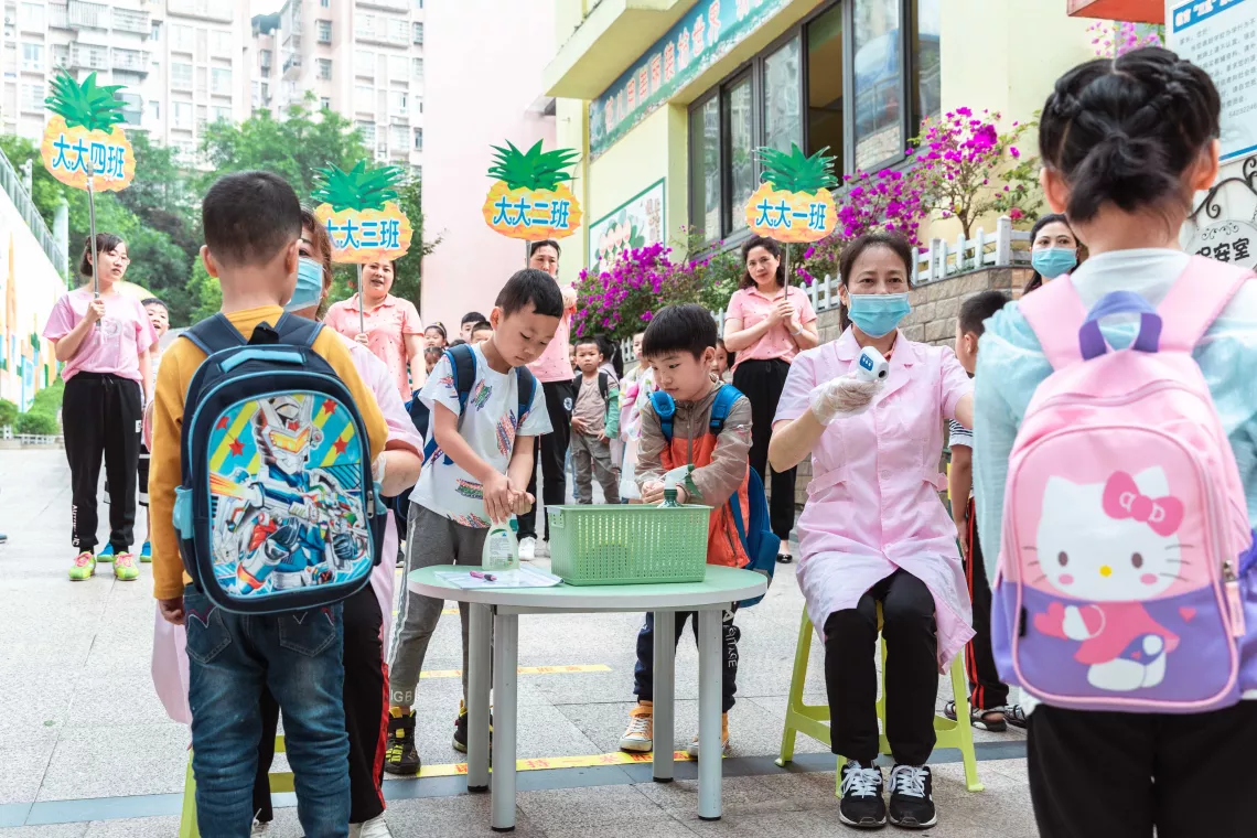 2020年6月4日，重庆忠县忠州幼儿园的孩子在入园前接受体温检测并使用免洗洗手液洗手。