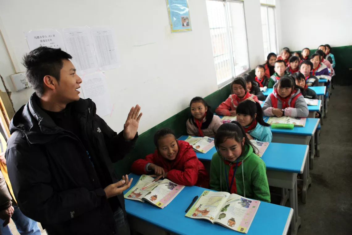 陈坤走进马摆小学的一间教室，并与孩子们打招呼。