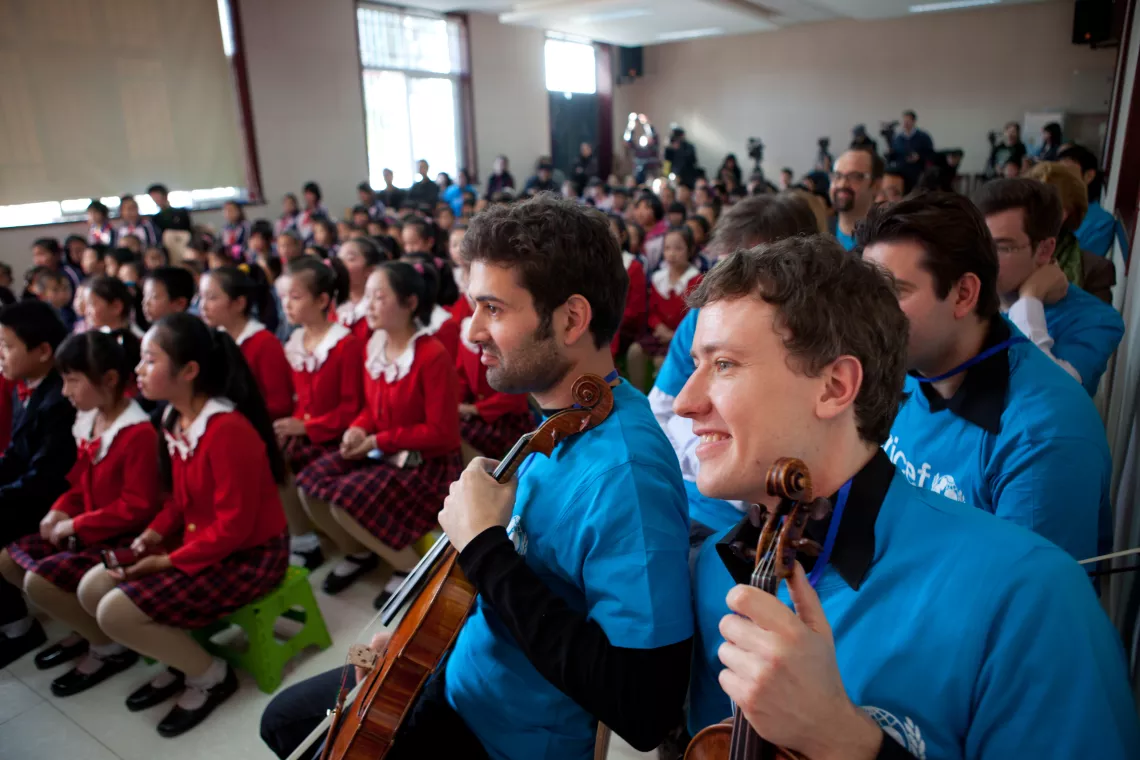 A group of musicians from the Berlin Philharmonic visit with migrant children in Beijing.