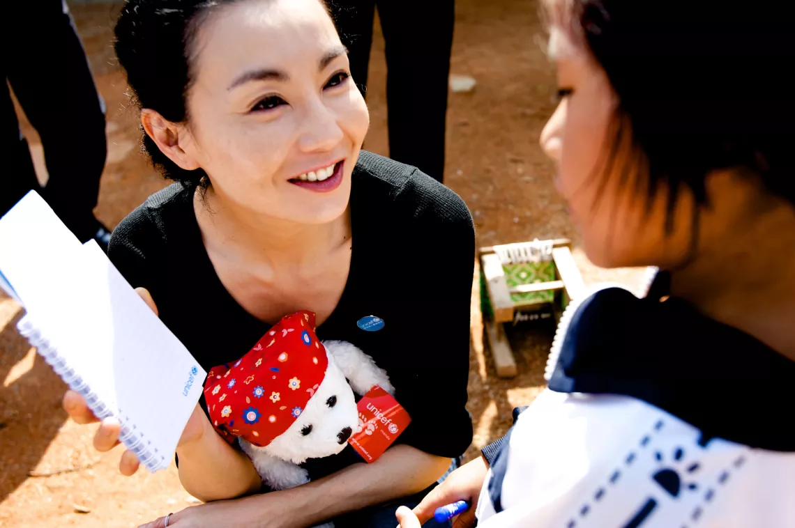 Maggie Cheung, UNICEF Ambassador visits with an eight-year old girl who has HIV.