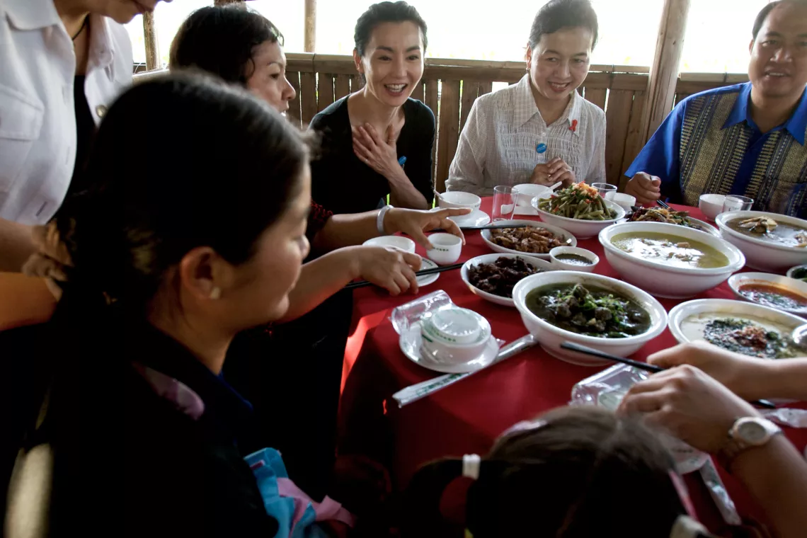 Having dinner with women and children who are living with HIV/AIDS