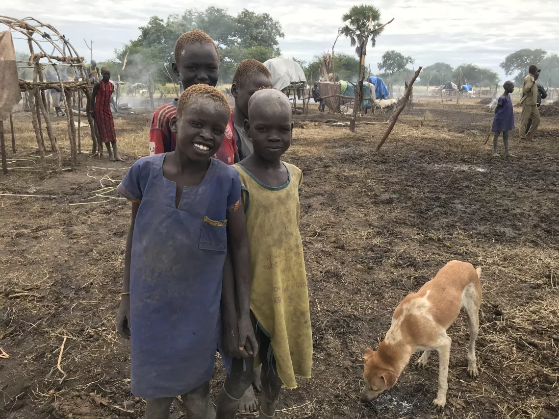 居住在南苏丹湖泊州Ameth Magak游牧营的儿童在自己住的房子面前摆姿势拍照。