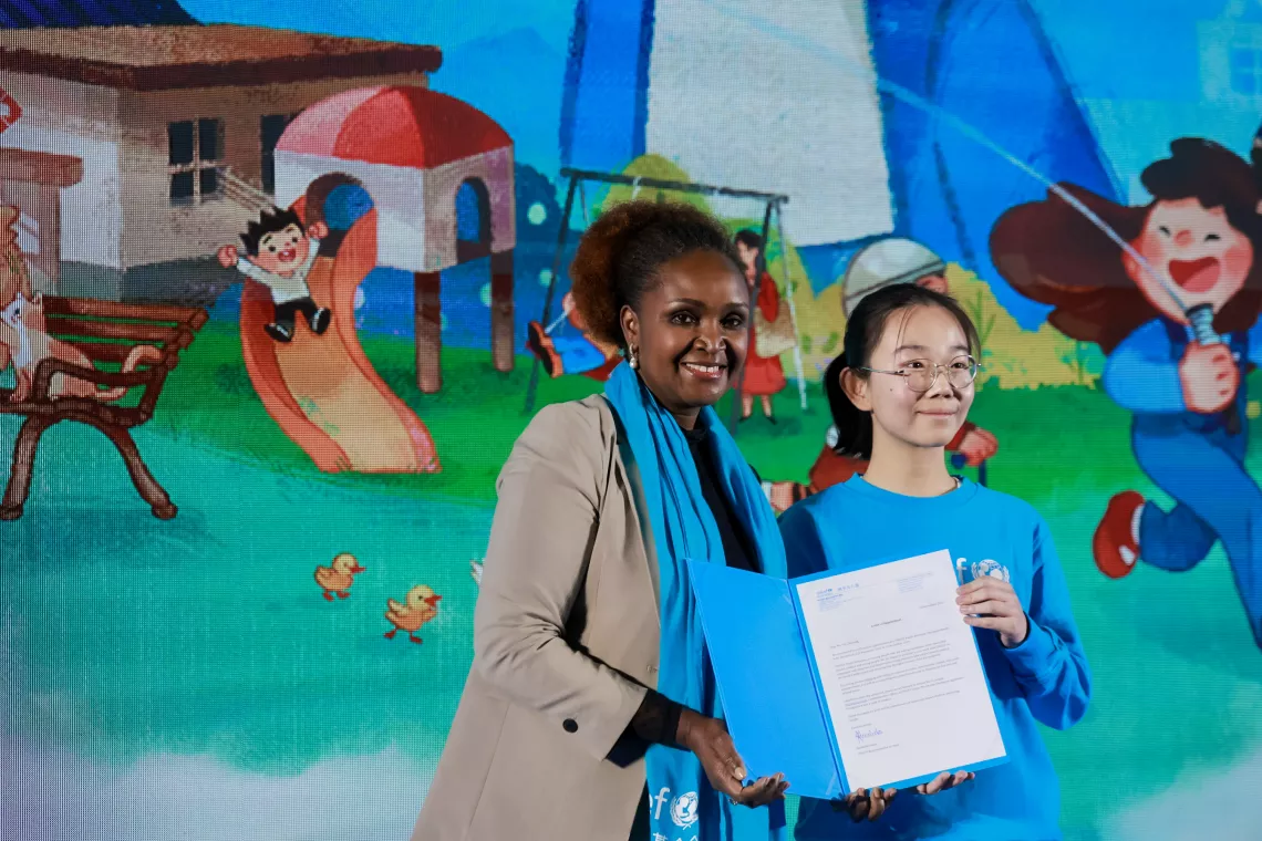 UNICEF Representative to China Amakobe Sande presents a letter of appointment to 14-year-old Yin Chuming during the World Children's Day event hosted by UNICEF China in Beijing on 20 November 2023. Yin Chuming was appointed as a UNICEF Youth Advocate, who will lead on water and climate action.