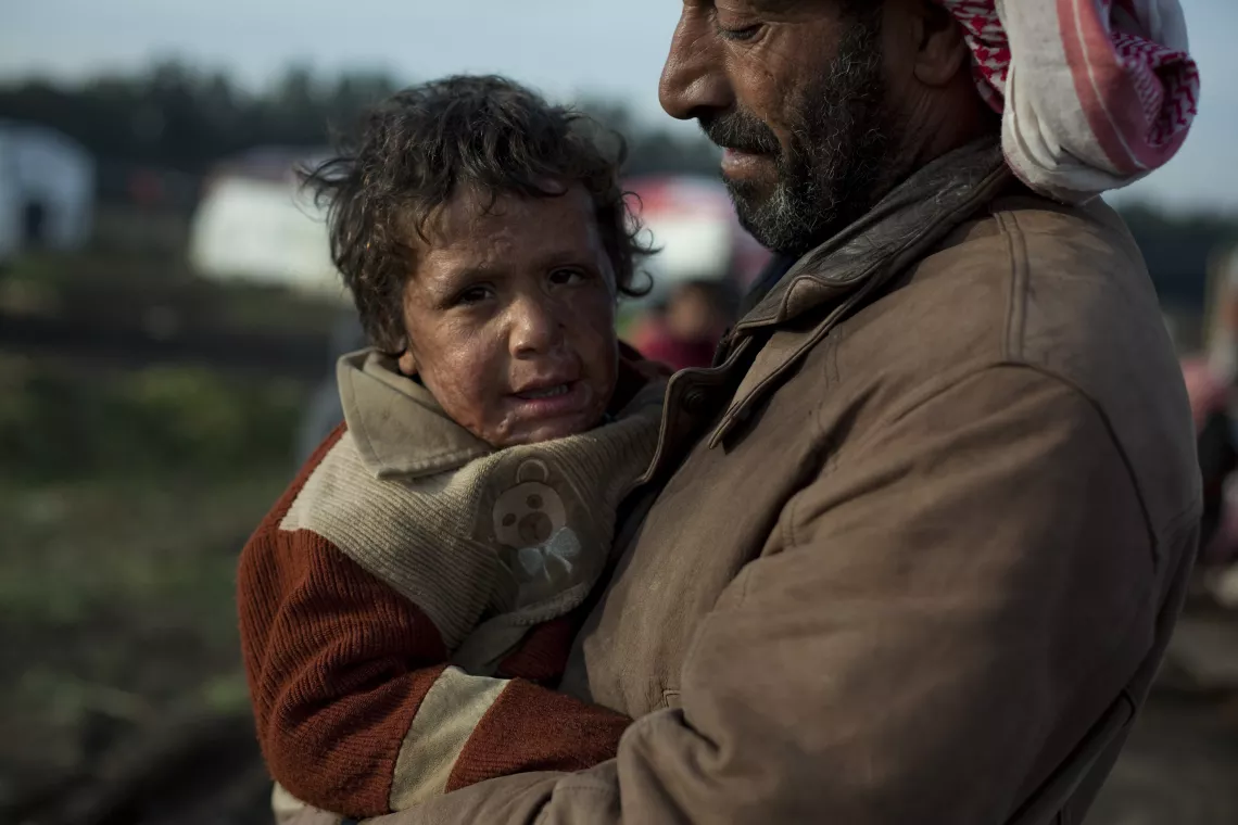 On 16 January, Adnan, 5, is held by his father in a makeshift encampment for Syrian refugees, in the Akkar Valley in North Governorate. 