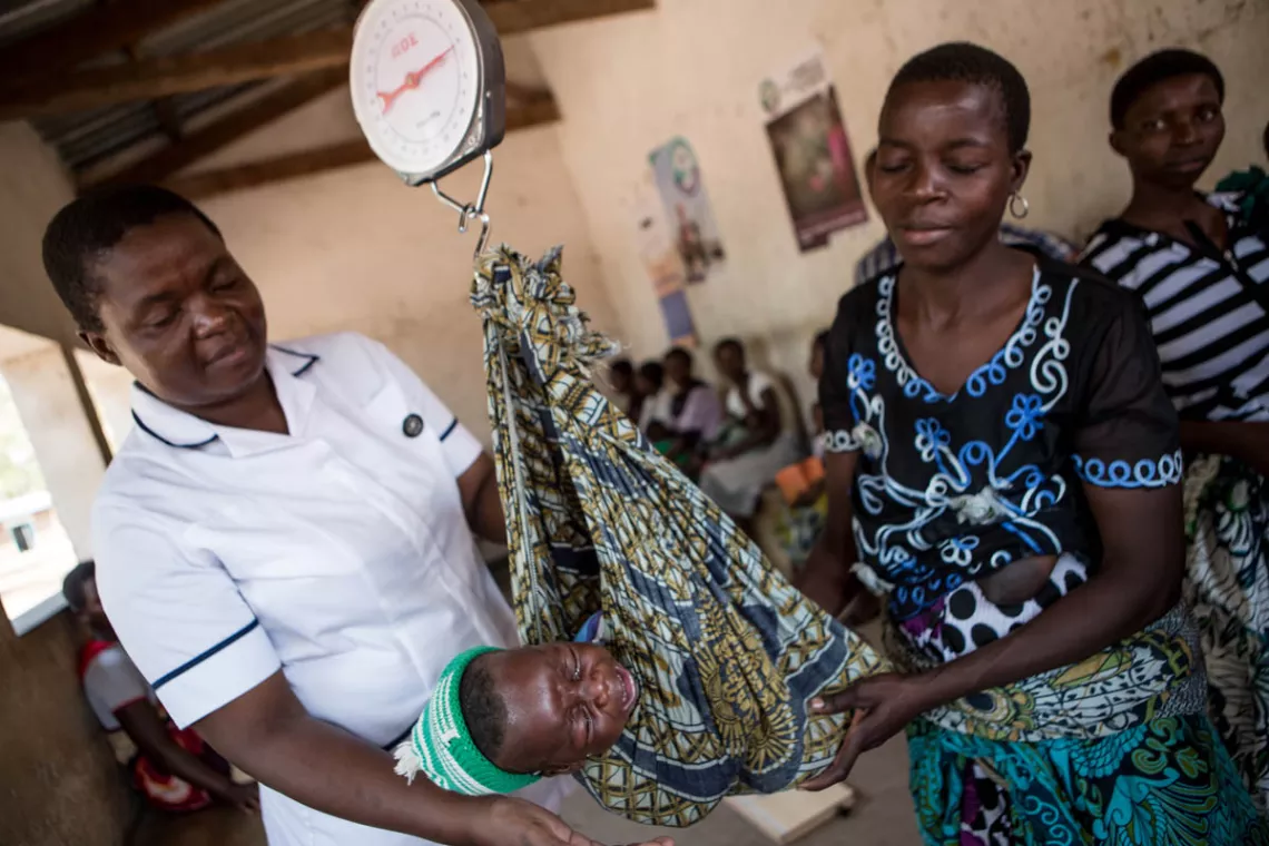在马拉维的Ngabu诊所，护士长Beatrice Chigamba在为一名婴儿称体重。