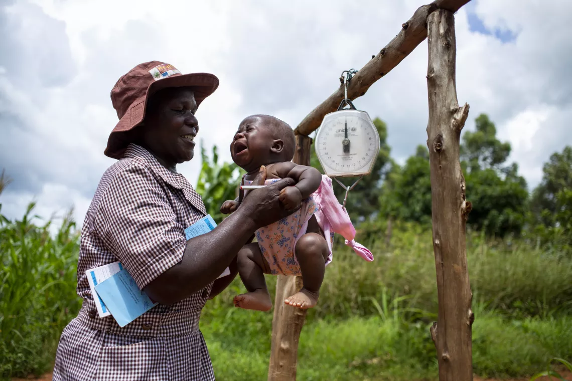 A community health worker, Tambudzai Vumisai (54), checks a five-month-old boy for signs of malnutrition in Nyahode, Zimbabwe, 6 February 2020.